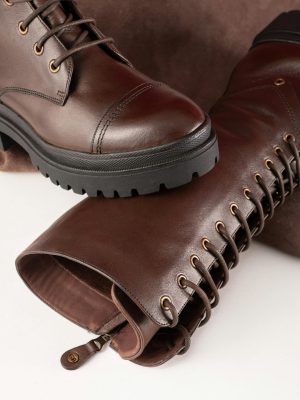 Elegant brown leather knee-high boots featuring lace ties, perfect for a sophisticated fashion look.